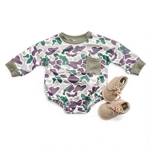 The Little Ranger Camo Bubble by Tiny Tot Bundles features green, purple, and white camo with olive trim and a chest pocket, paired with beige baby shoes.