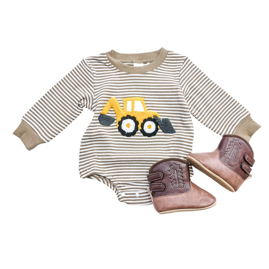 The Tiny Tot Bundles Dig & Go Striped Bubble baby romper with a yellow excavator graphic is paired with small brown cowboy boots, both displayed on a white background.