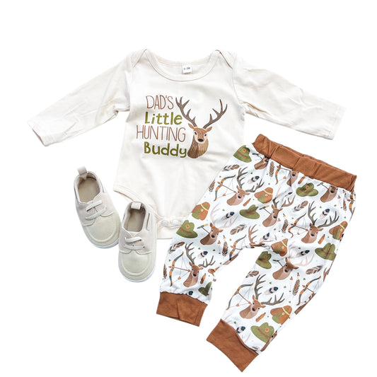 The Tiny Tot Bundles Dad's Deer Buddy Outfit includes a long-sleeve bodysuit with “Dad’s Little Hunting Buddy” and deer graphic, matching deer-patterned pants and hat, plus beige baby shoes.