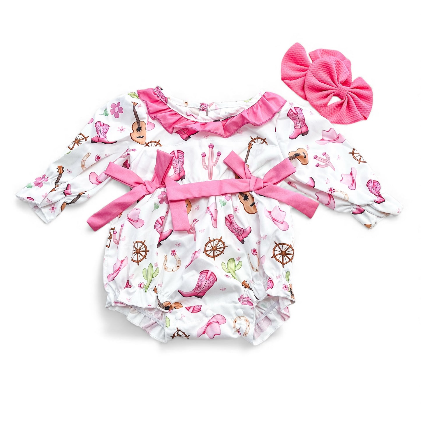 The Tiny Tot Bundles Western Dream Romper is a long-sleeved baby girl’s outfit with pink Western-themed prints, ruffles, bows, and comes with a large matching pink hair bow.