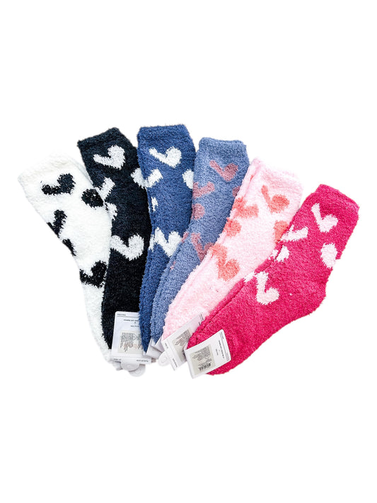 Six pairs of love & repeat Sweetheart Lounge Socks in white, black, blue, light pink, pink, and magenta with heart patterns are displayed side by side on a white background with tags attached.