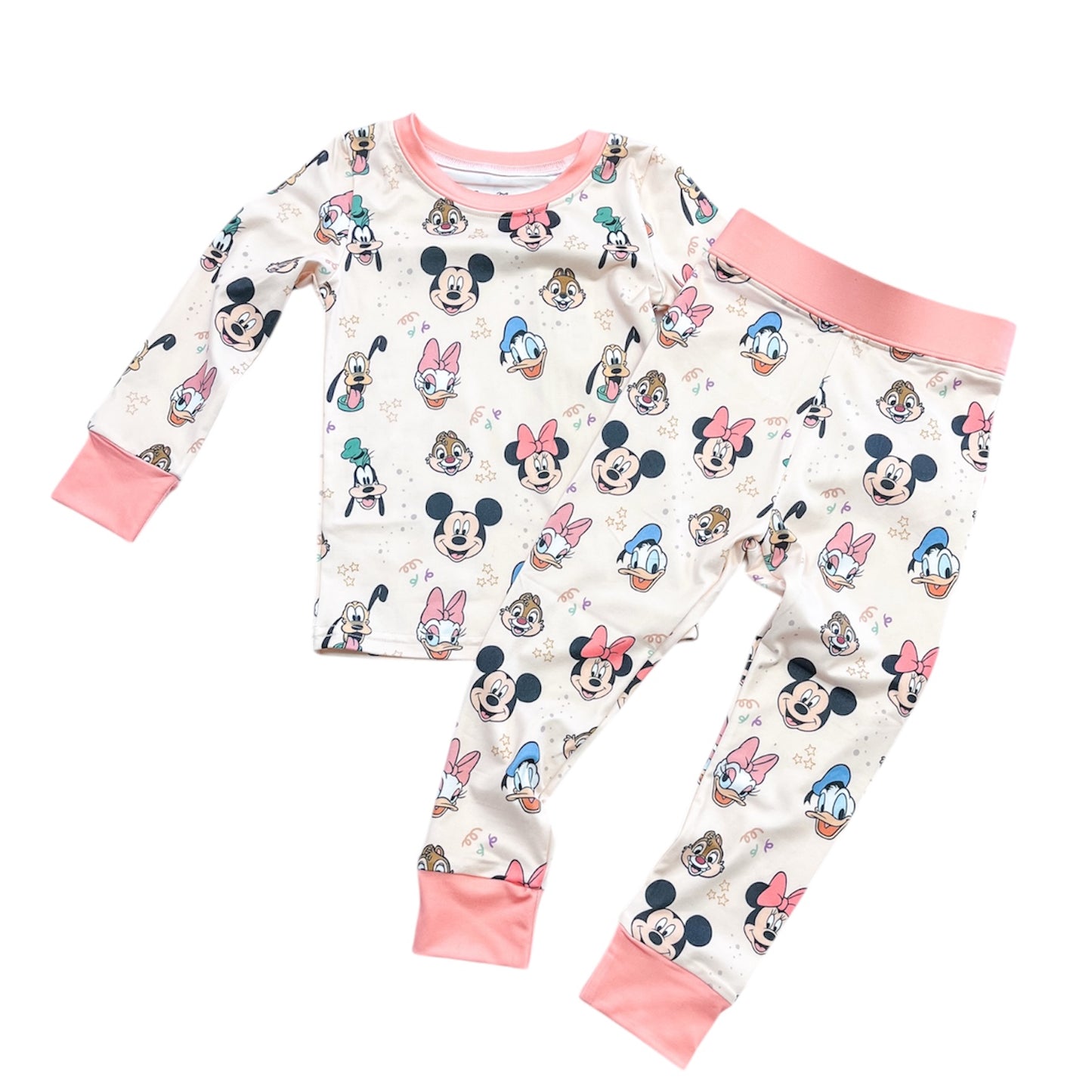 The Magic Friends Jammies Set by Tiny Tot Bundles is a long-sleeve children’s pajama set with pants, featuring an all-over Disney character print and light pink cuffs and collar.