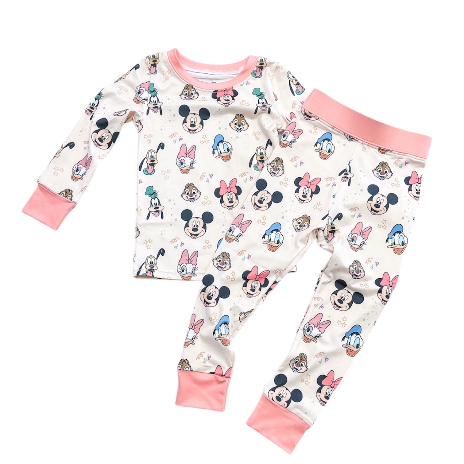 The Magic Friends Jammies Set by Tiny Tot Bundles is a long-sleeve children’s pajama set with pants, featuring an all-over Disney character print and light pink cuffs and collar.