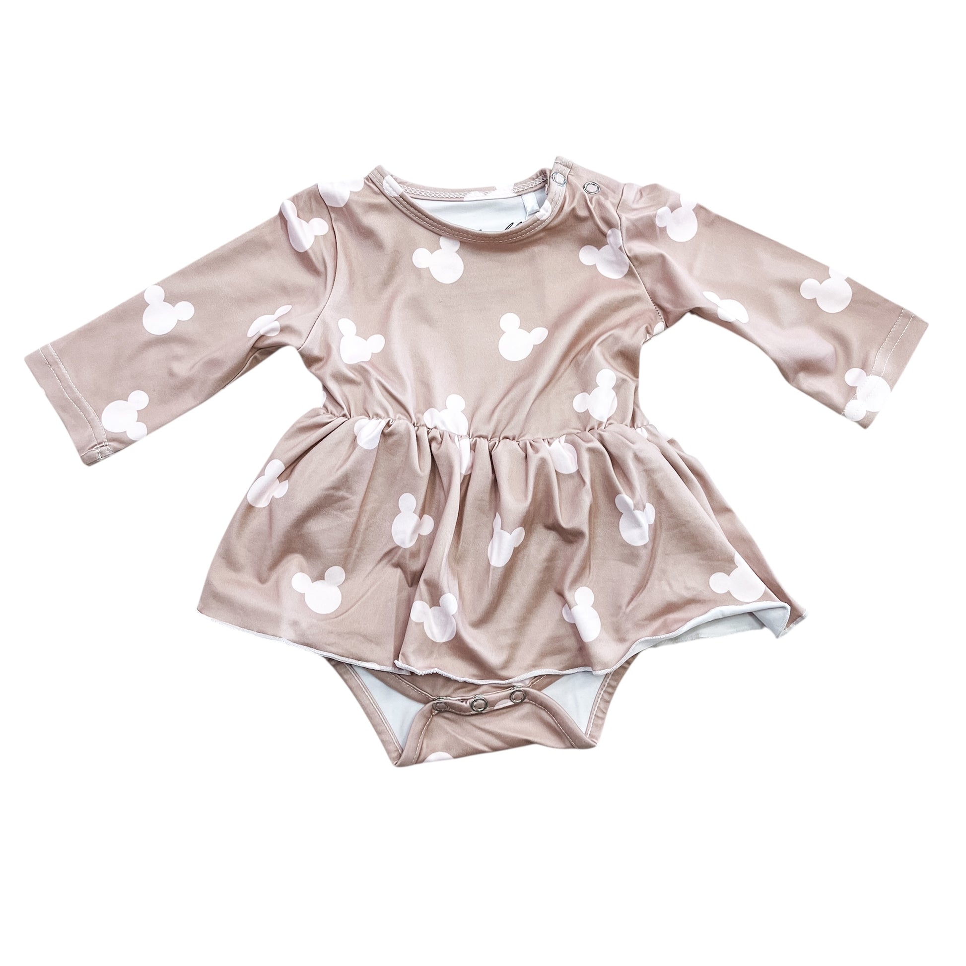 The Cozy Mouse Longsleeve Twirl Romper by Tiny Tot Bundles is a light brown baby romper dress with white Mickey Mouse head silhouettes, a skirted waist, and snap closures at the bottom.