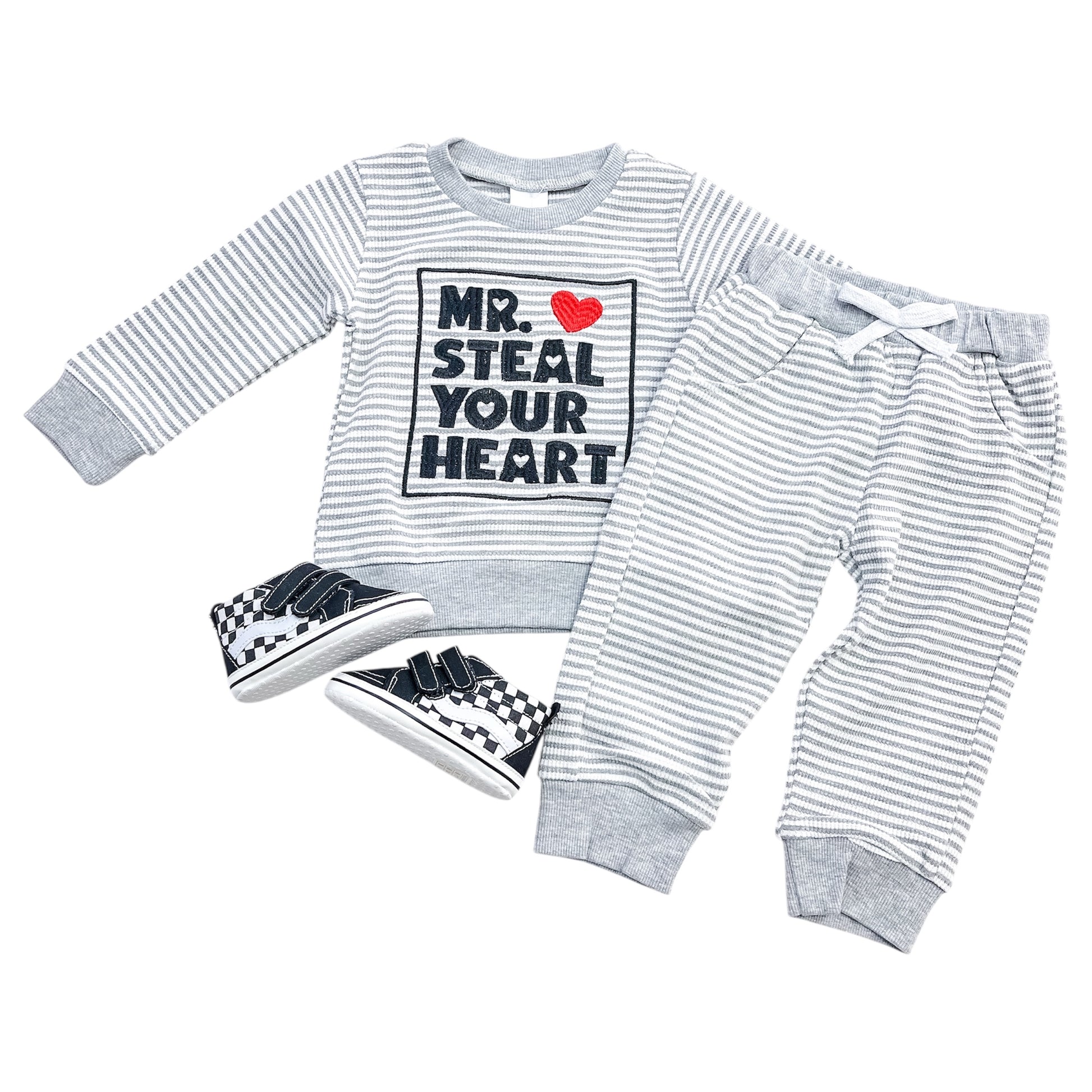 The Little Hearts Stealer Set by Tiny Tot Bundles includes a gray and white striped long-sleeve shirt with "Mr. Steal Your Heart" and red heart graphic, matching drawstring pants, and black-and-white checkered sneakers.