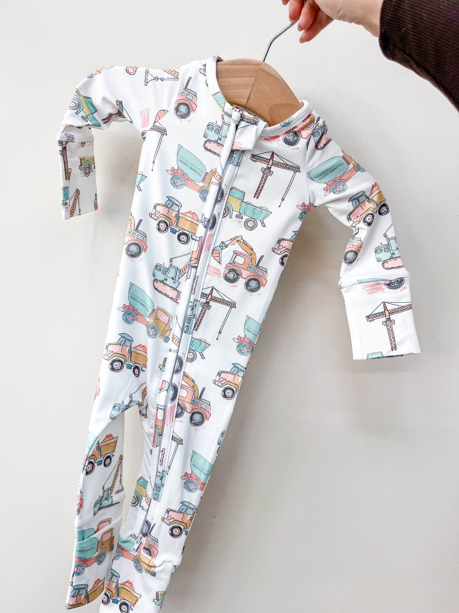The Construction Crew Zippy by Tiny Tot Bundles is a baby romper featuring trucks.