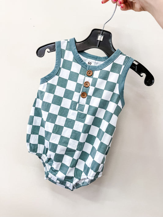 A hand holds a hanger displaying the Tiny Tot Bundles Checkmate Tank Romper, a sleeveless baby outfit with a green and white checkered pattern and three brown buttons on the front.