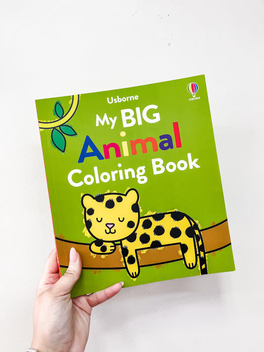 A hand holds a green book titled "My Big Animal Coloring Book" by Harper Collins, featuring a yellow and black spotted leopard resting on a tree branch.