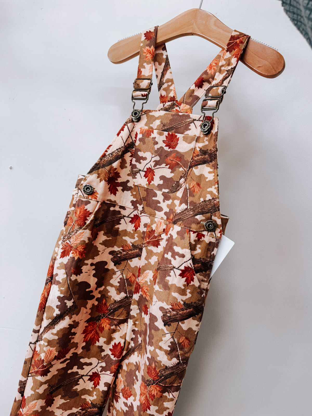 Autumn Camo Corduroy Overalls in corduroy with a camouflage print featuring brown and orange autumn leaves.