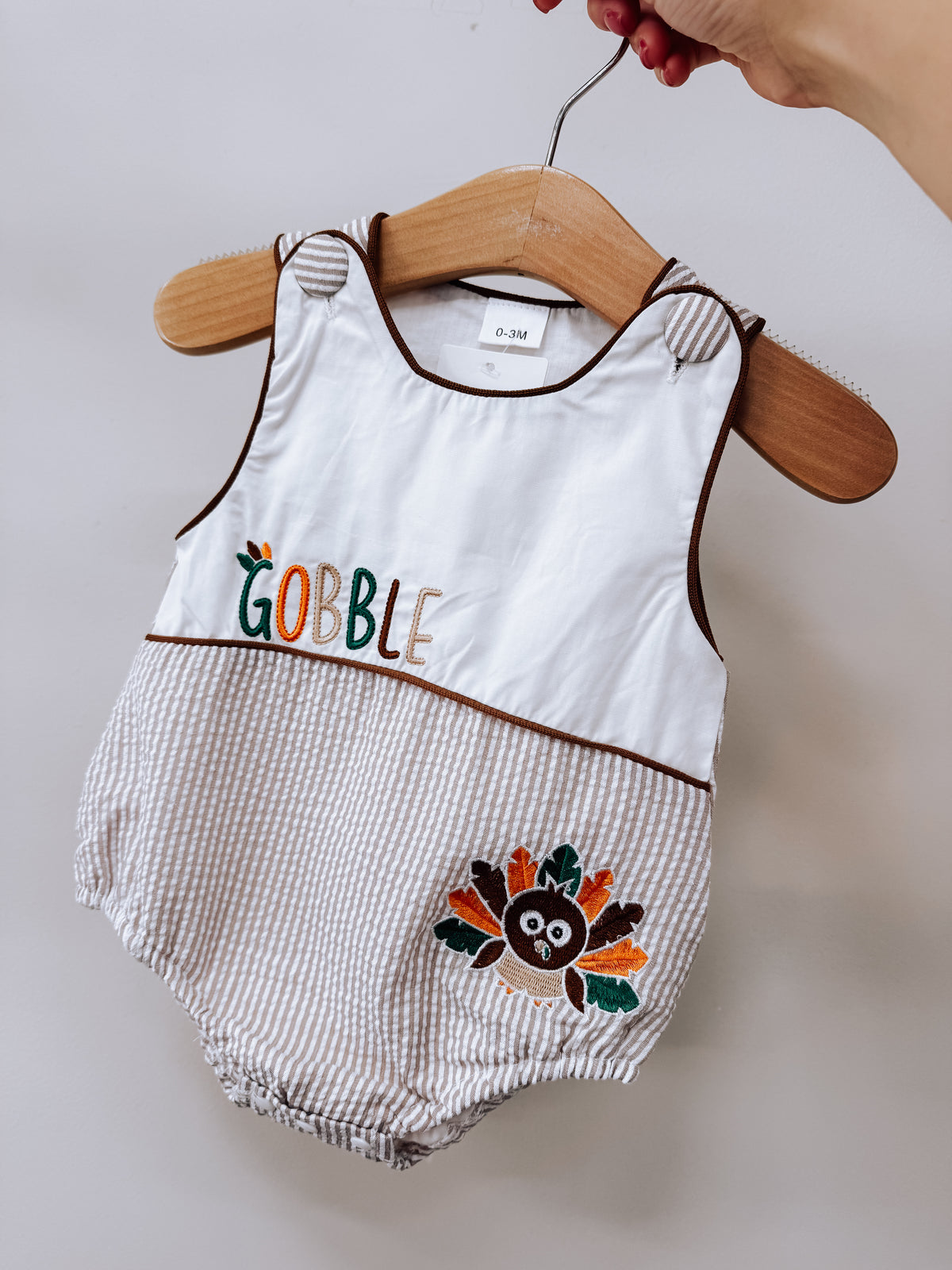 Tiny Tot Bundles Gobble Turkey Embroidered Romper featuring a turkey embroidery and the text GOBBLE on the front.