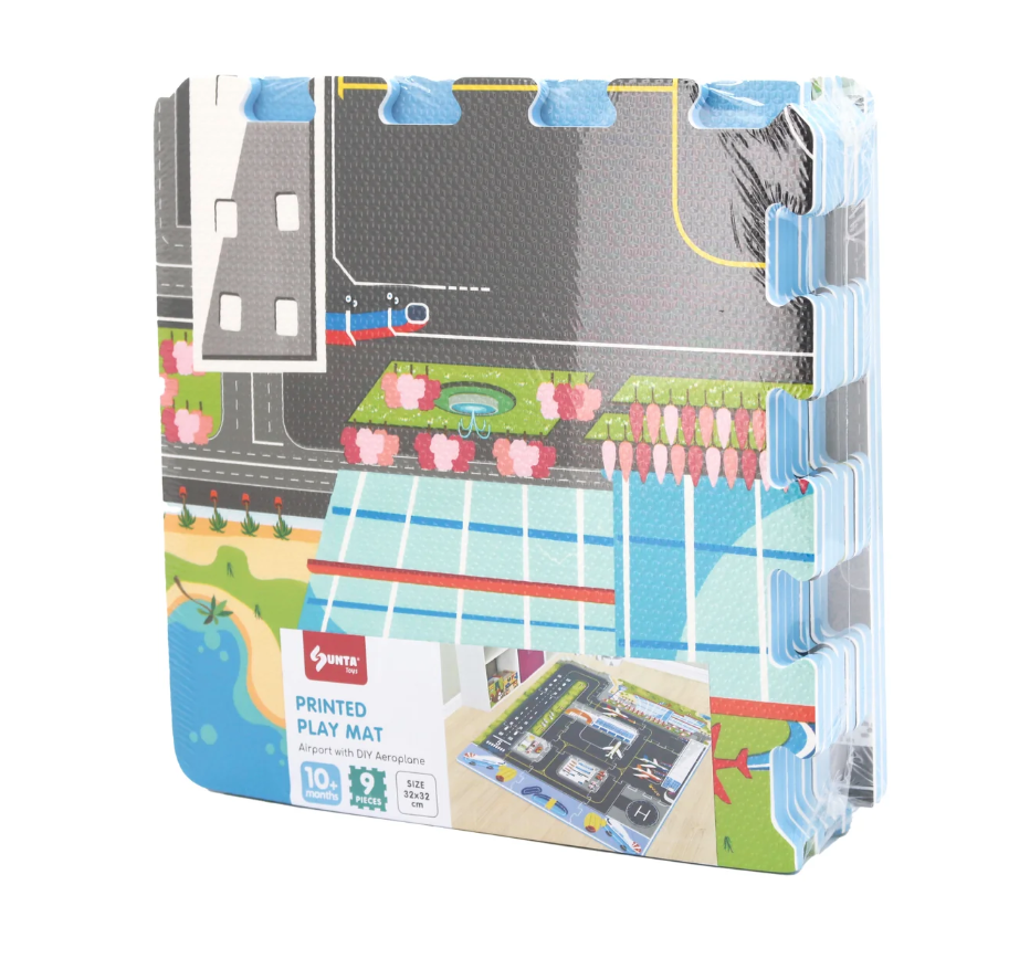 The Triaction Plane & Airport Play Mat is a set of interlocking foam mats featuring an airport and city design with roads, parking spaces, a pond, and greenery. The set comes packaged together with a front product label.