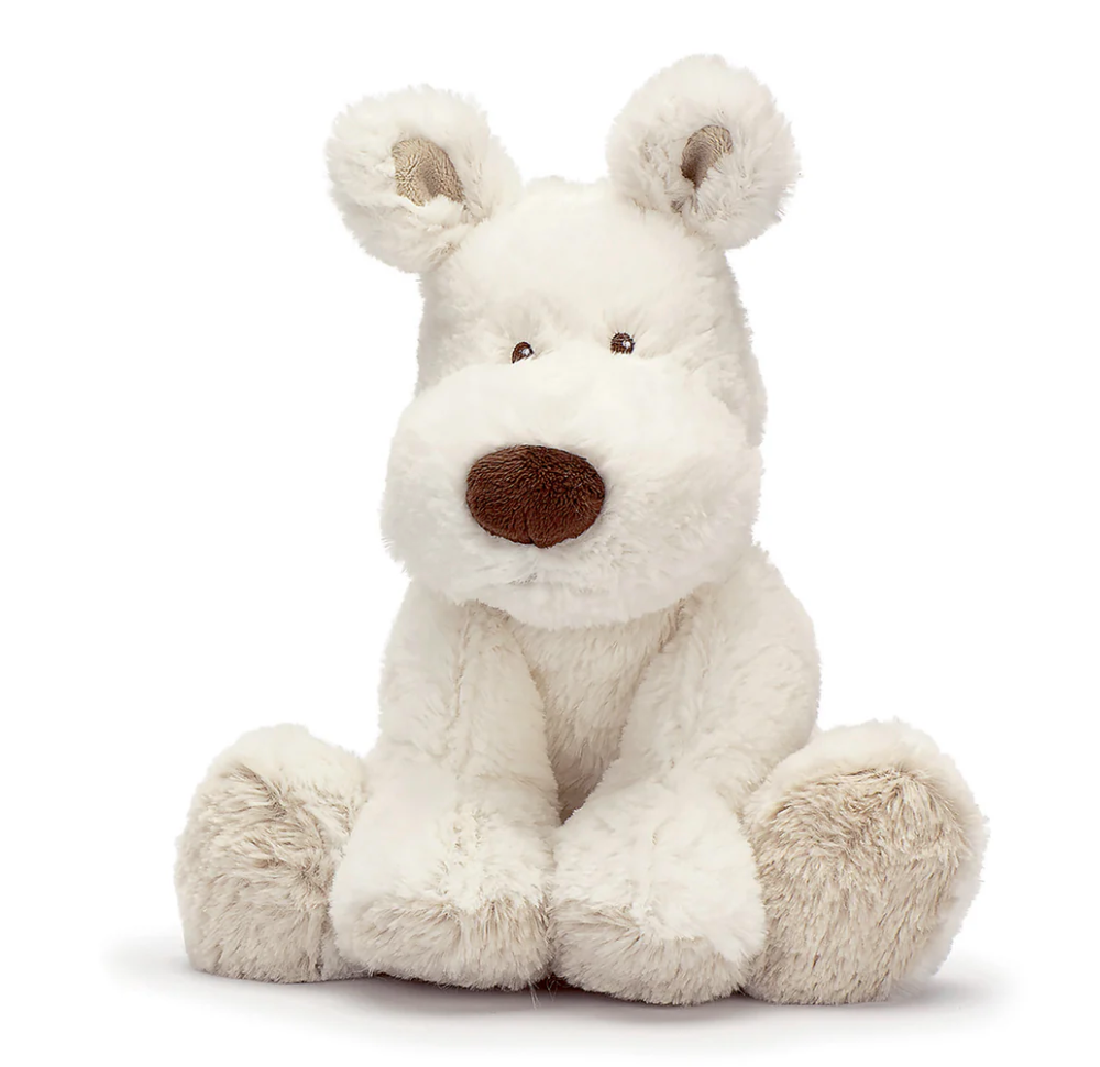 The Triaction Teddy Dog Plush features soft, fluffy white fur, a large brown nose, small black eyes, and floppy ears, sitting upright on a white background.