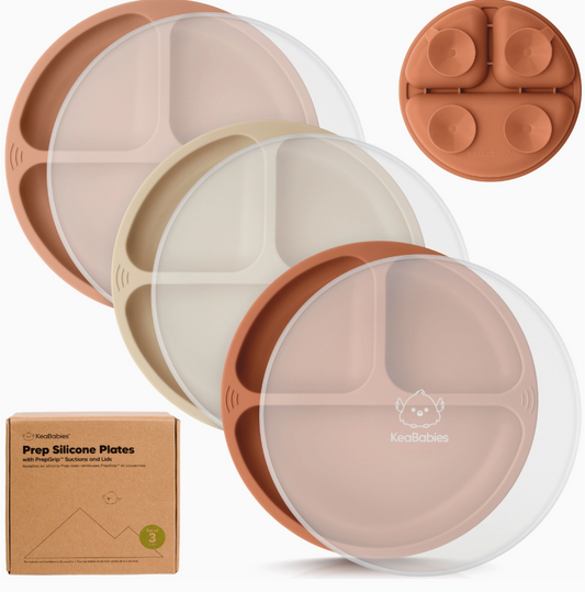 Three round, divided keababies Prep Suction Plates in terracotta shades are stacked with clear lids. A matching suction base is above, and a box labeled “3-Pack Prep Suction Plates - Terracotta” sits on the left.