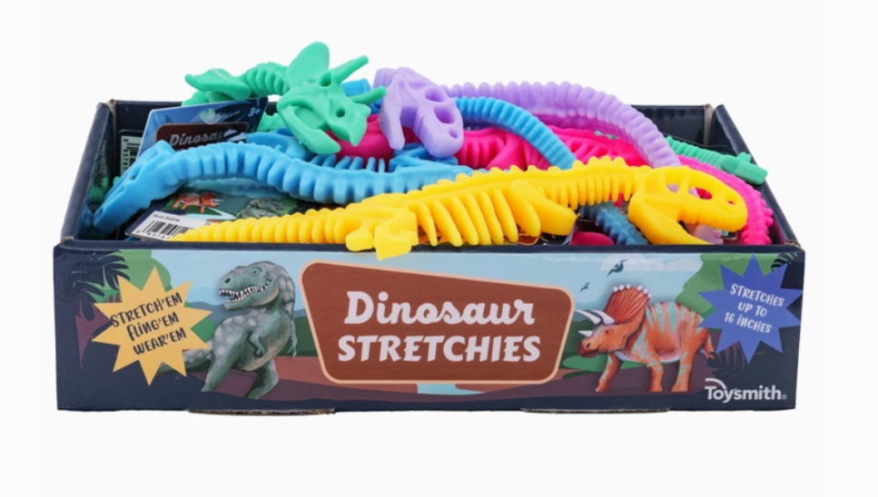 A Toy Smith Dinosaur Stretchies box features cartoon dinosaurs and text about stretchability, containing colorful stretchy dinosaur toys in yellow, green, blue, purple, and pink.