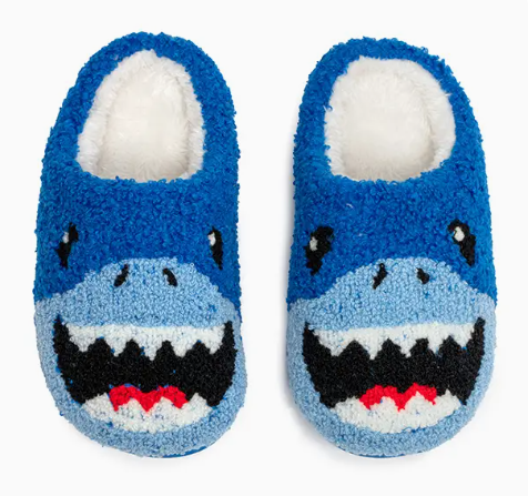 The Living Royal Snuggle Shark Slippers are fluffy blue slippers styled like sharks, complete with cartoon eyes, open mouths, white teeth, and red tongues.