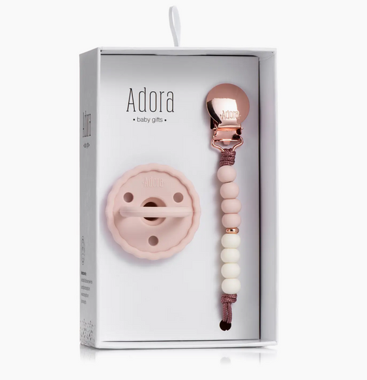 The Adora Scalloped Blush Ombre Pacifier Clip Set includes a pale pink silicone pacifier and matching beaded clip with rose gold clasp, presented in a gift box on a white background.