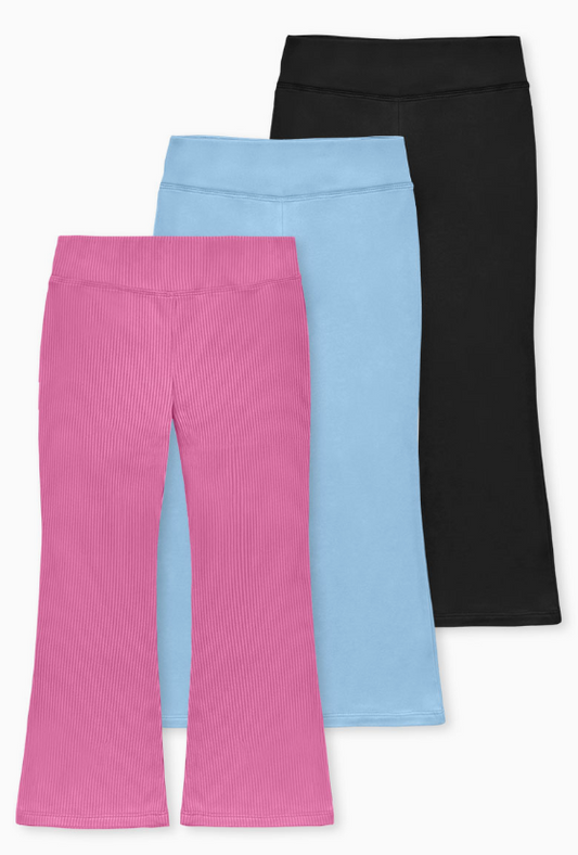 Three pairs of Cutie Patootie Soft Stretch Leggings are shown overlapping: the front pair is pink with a ribbed texture and flared legs, the middle pair is light blue, and the back pair is solid black.