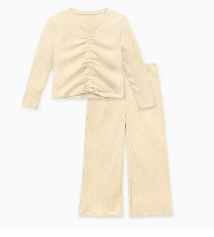 The Cutie Patootie Weekend Comfort Ruched Set is a beige ribbed pajama set with a ruched long-sleeve top and matching wide-leg pants, displayed flat on a white background.