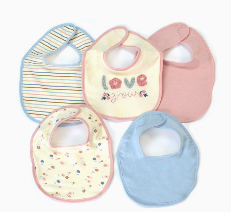 The Lollipop Dreams Love & Grow Bib Set includes five baby bibs in pink, blue, cream, and multicolored, featuring stripes, flowers, pastels, and one embroidered with “love grow” and floral details.