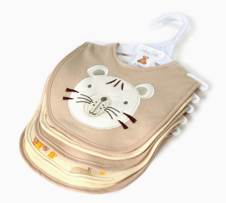 The Little Tiger Bib Set by Lollipop Dreams features beige and cream baby bibs with animal face designs, stacked and hanging on a white plastic hanger. The top bib has a cute embroidered tiger face.