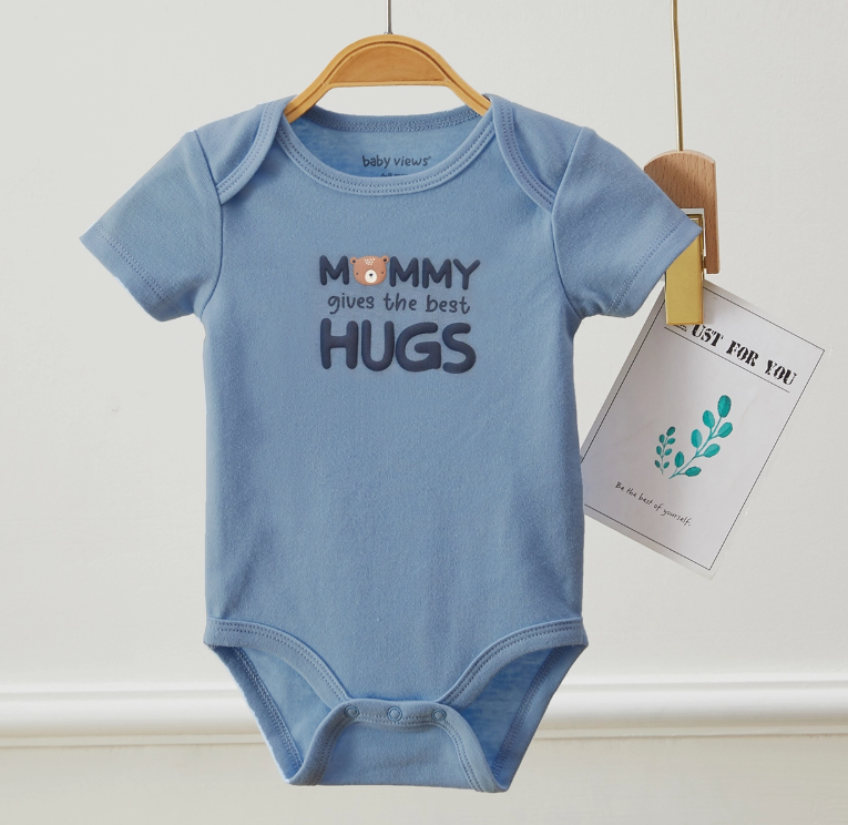 A blue "Mommy Hugs Bubble Trio" onesie by Lollipop Dreams hangs on a hanger with “Mommy gives the best hugs” and a bear face on the chest, plus a card reading “JUST FOR YOU” attached beside it.