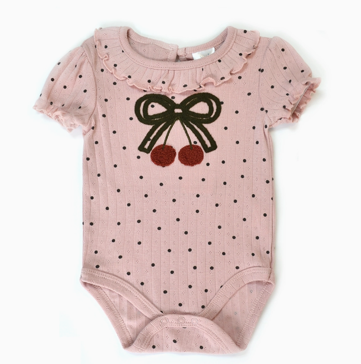 The Cherry Bow Bubble Trio by Lollipop Dreams is a pink baby onesie with short ruffled sleeves, black polka dots, a ruffled collar, and a cute bow and cherry chest design.