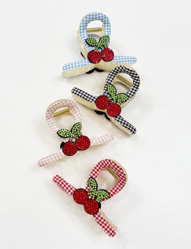 The love & repeat Sweet Cherry Gingham Hair Claw comes in blue, black, pink, and red plaid, each adorned with sparkling red cherries and green leaves, displayed on a white background.