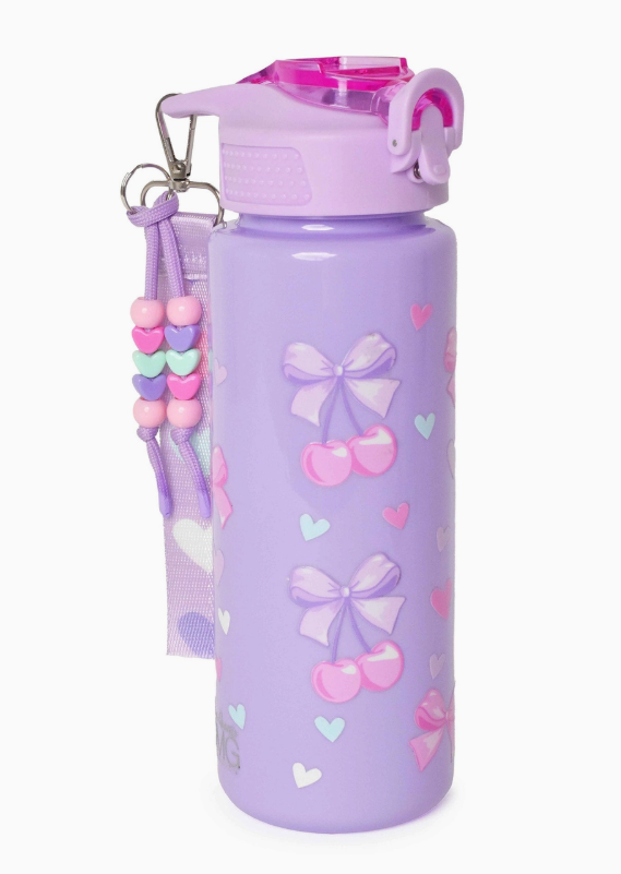 The omg Accessories Lavender Cherry Dream Water Bottle features pink and purple bows, cherries, heart designs, a pink flip-top lid, and a lilac strap with colorful heart-shaped beads.