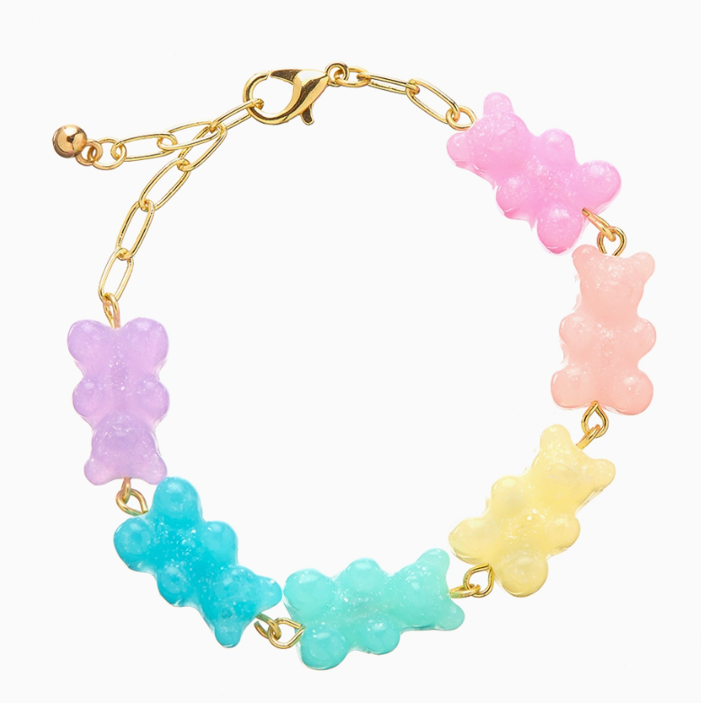 The Lil Bear Thang Bracelet by top trenz inc. is a gold chain with six gummy bear charms in pink, peach, yellow, green, blue, and purple, arranged in a circle.