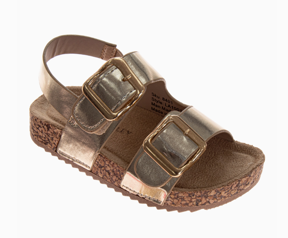 The Golden Sunshine Sandals by Josmo Shoes Inc feature a metallic gold finish, two large gold buckles on the straps, a slingback heel, and a cork-textured sole.