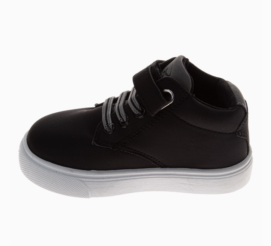 The Midnight Mini High-Tops by Josmo Shoes Inc are black children's sneakers featuring a white sole, gray laces, and a hook-and-loop strap, shown from the side on a plain white background.
