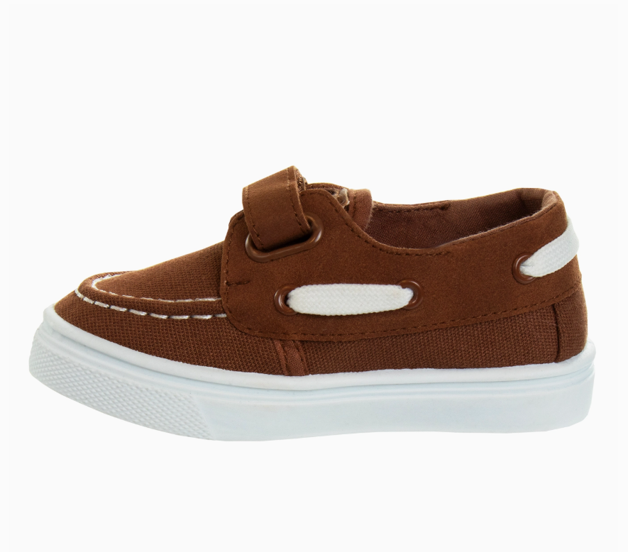 The Sandy Shore Sneakers by Josmo Shoes Inc are brown canvas boat shoes for children, featuring a white rubber sole, white stitching, and a Velcro strap across the top.
