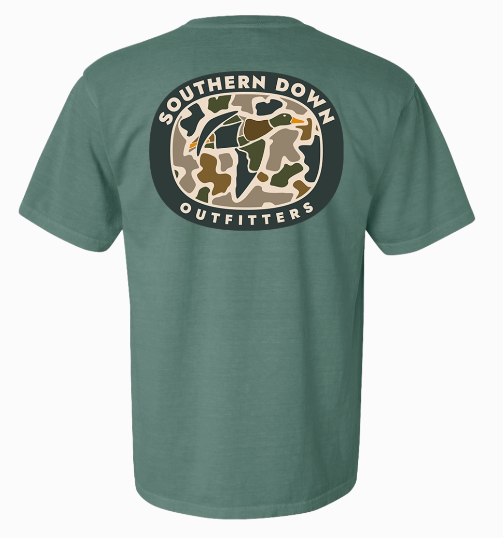 The Duck Camo Men T-Shirt by Wild Trail Outfitters is a green short-sleeve tee with an oval camo graphic on the back, showing a flying duck and the words “Wild Trail Outfitters” encircling the design.
