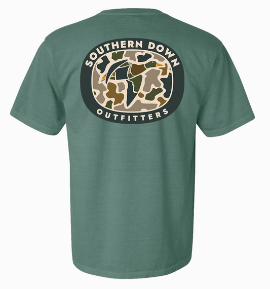 The Duck Camo Men T-Shirt by Wild Trail Outfitters is a green short-sleeve tee with an oval camo graphic on the back, showing a flying duck and the words “Wild Trail Outfitters” encircling the design.