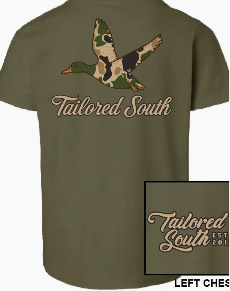 The Camo Duck Youth T-shirt by Wild Trail Outfitters is olive green, featuring a camo flying duck and "Tailored South" on the back, with the Tailored South Est. 2017 script logo on the front left chest.