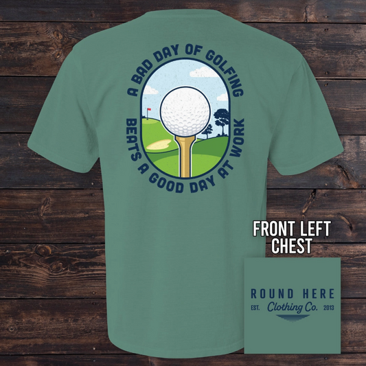 The Old North State's Good Day Golf Men's Tee is green, with a large back graphic of a golf tee and ball on a fairway, reading "A BAD DAY OF GOLFING BEATS A GOOD DAY AT WORK," and the Round Here Clothing Co. logo on the front chest.