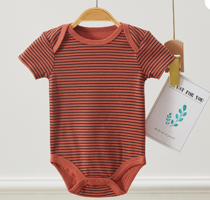 The "Wild About Mommy Bubble Trio" by Lollipop Dreams—a short-sleeved, black and rust-striped baby onesie—hangs on a wooden hanger with a card featuring a green leaf design and text attached.