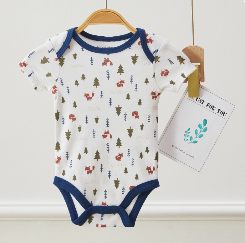 The Wild About Mommy Bubble Trio by Lollipop Dreams is a short-sleeve baby onesie with blue trim and a forest print of trees and animals, hanging on a wooden hanger with a "JUST FOR YOU" tag attached.