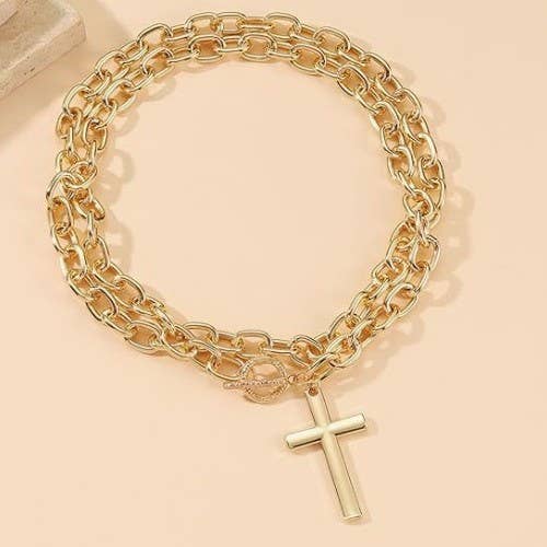 JOSSLYN by wall to wall Cross Chunky Chain Necklace featuring a double-layered gold chain with a toggle clasp and a cross pendant.