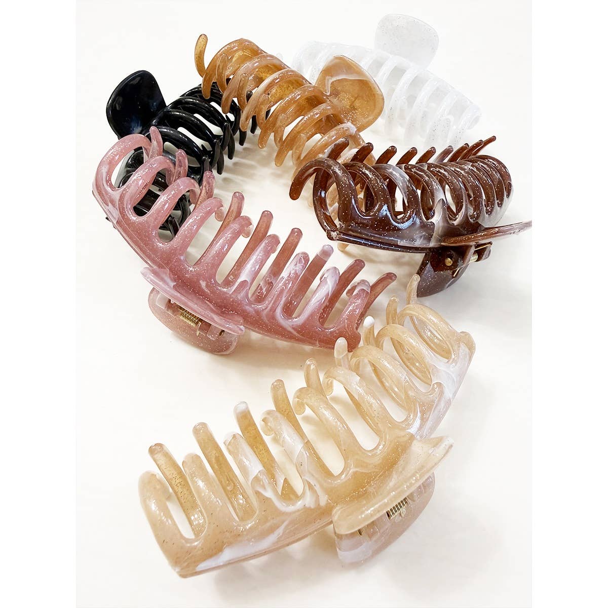 Five Marbled Round Comb Hair Claw Clips by Love and Repeat, in assorted colors—black, white, brown, pink, and beige—are displayed in a circle on a white background.