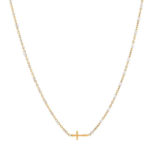 The JOSSLYN by wall to wall Dainty Cross Necklace features a delicate gold chain adorned with small white beads and a horizontal gold cross pendant at the center.