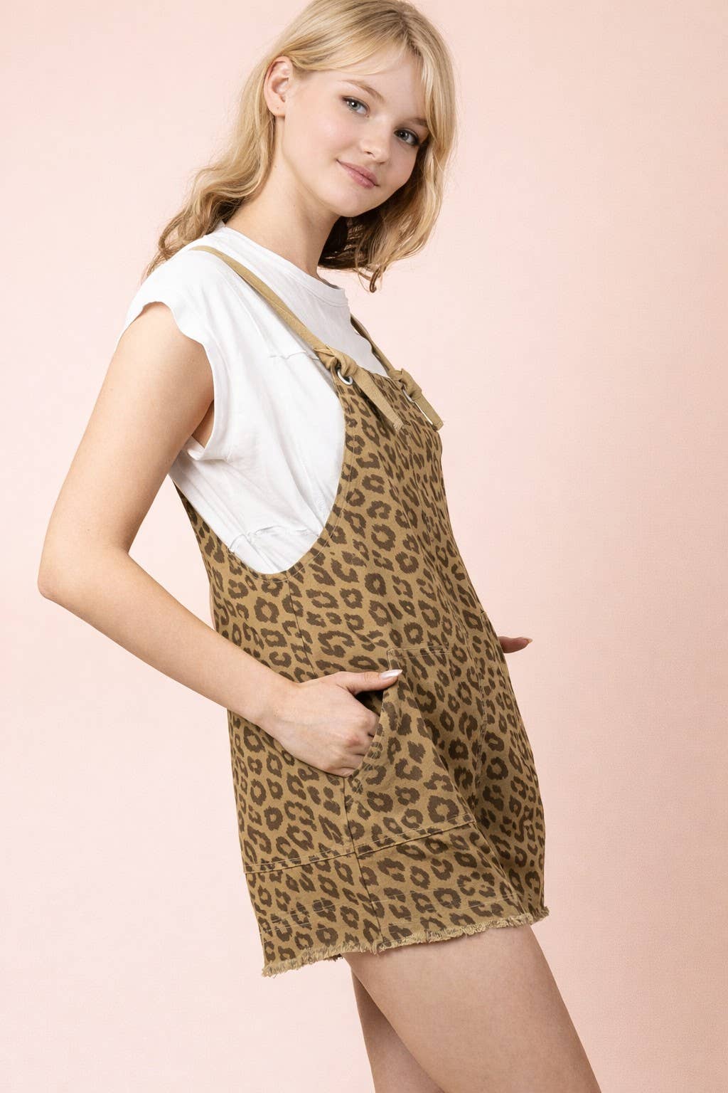 A person wears a white t-shirt under a VERY J Leopard Print Casual Romper featuring a leopard-print pattern and a frayed hem.