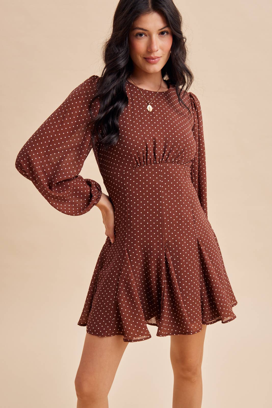 In Loom Polka Dot Flared Mini Dress in brown with a white polka dot pattern and a pleated skirt.