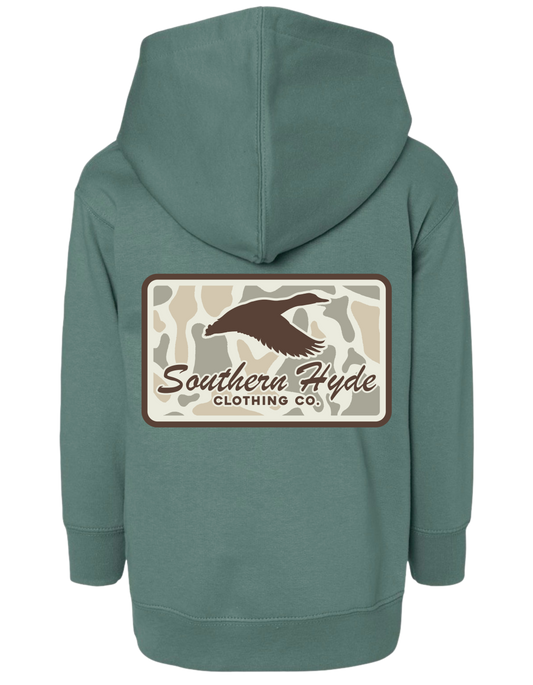 Back view of a green Camo Skies Green Hoodie featuring a rectangular graphic with a camouflage background, a brown duck silhouette, and the text Southern Hyde Clothing Co.
