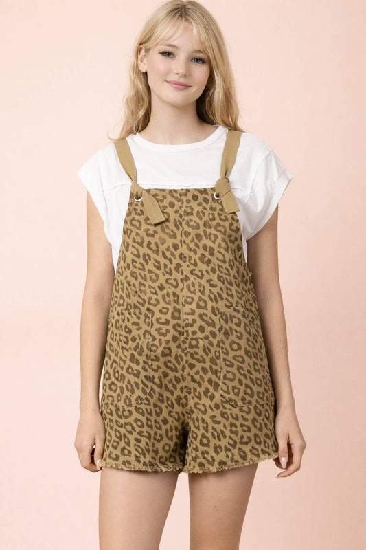 A woman wearing a white t-shirt under a VERY J Leopard Print Casual Romper, featuring a tan and brown leopard print, shoulder ties, and a frayed hem.
