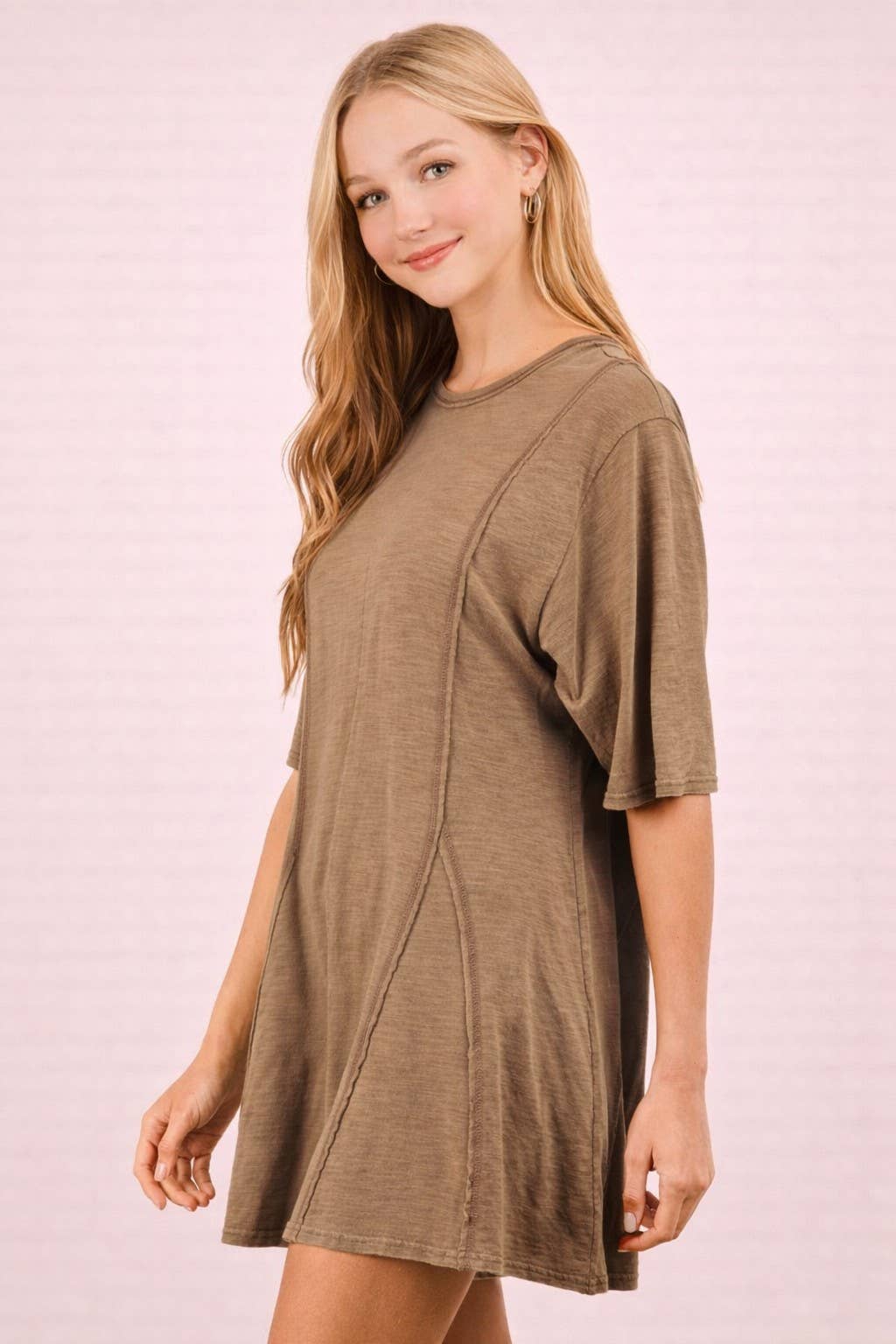 Woman wearing a brown VERY J Mineral Washed Oversized Romper with exposed seam detailing and short sleeves.