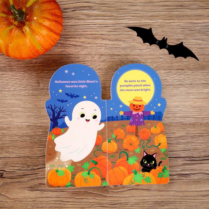 Open copy of Little Ghost by Maggie Fischer, a Halloween-themed children’s book from Simon & Schuster, displayed on a wooden surface with illustrations of a smiling ghost, pumpkins, a scarecrow, black cat, and bat visible inside; a small pumpkin is placed nearby.