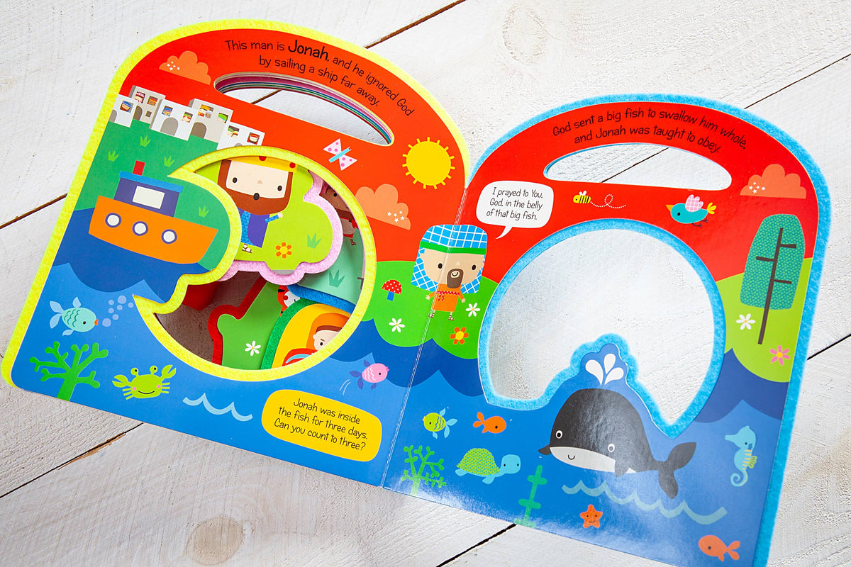 The Busy Windows Bible Stories Felt Book by BroadStreet Publishing Group, LLC features vibrant children’s pages about Jonah, with cartoon illustrations showing him near a boat and inside a big fish, alongside ocean animals and engaging text narrating the biblical story.