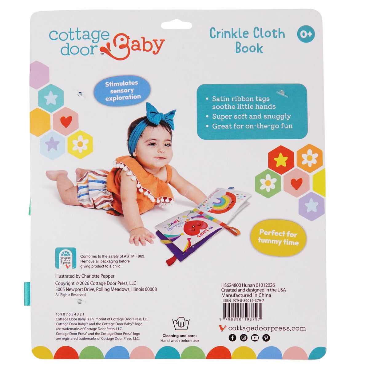A baby wearing a blue headband lies on a colorful blanket, reaching for the Hello, Sunshine! Cloth Book from Cottage Door Press. Text highlights the book’s features—satin ribbon tags, tactile fun, and crinkle pages—and its benefits for tummy time and sensory exploration, making this cloth book an ideal choice for little hands and curious minds.