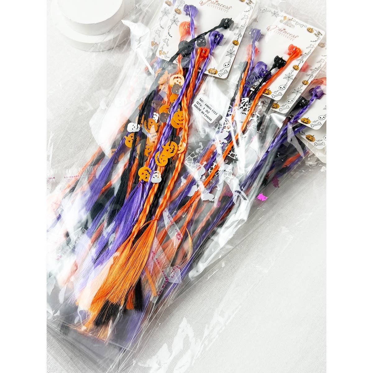 Three Love and Repeat Halloween Braid Hair Extension Clips in purple, orange, and black, featuring small jack-o-lantern and skeleton charms.